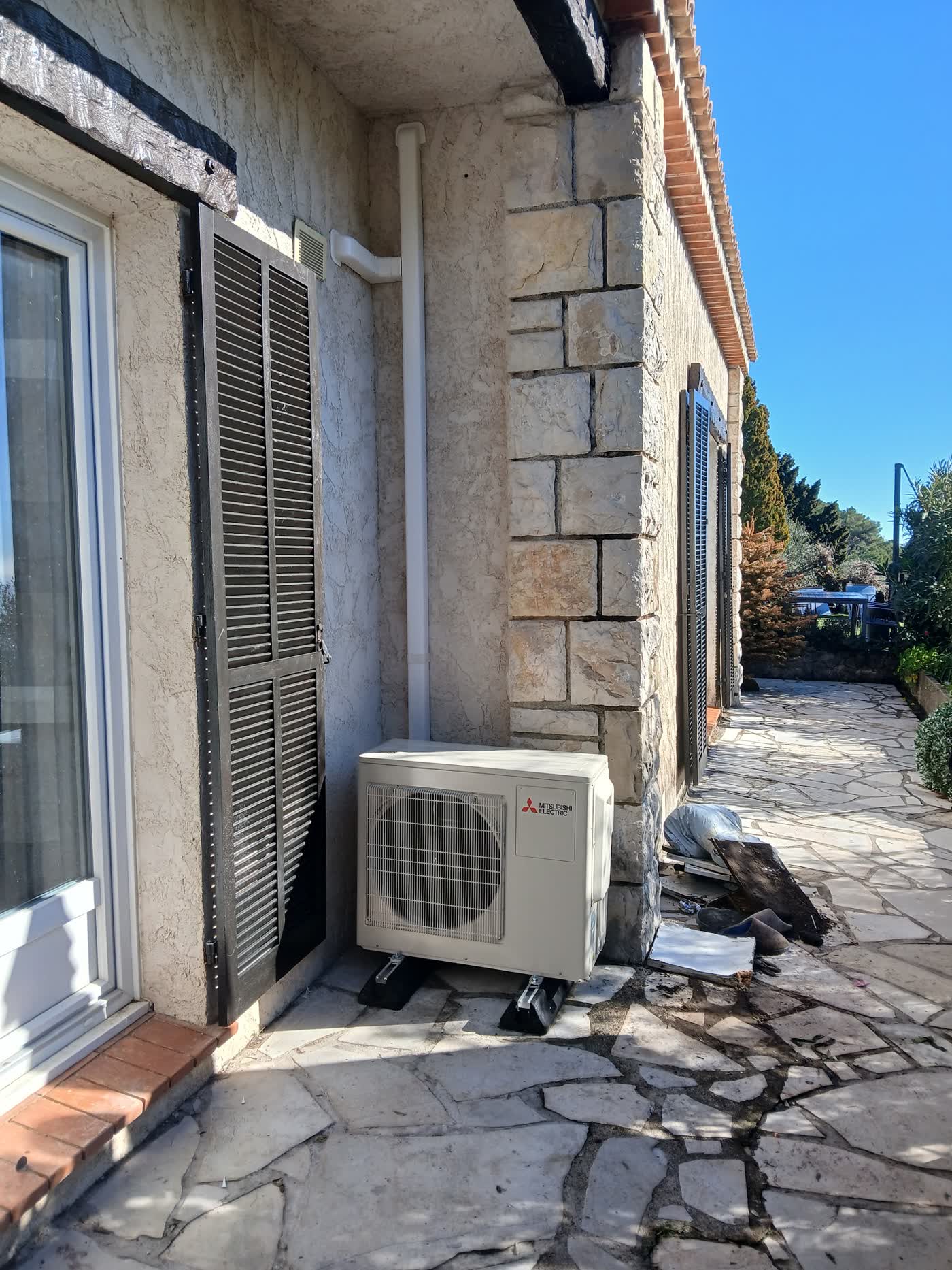 Groupe extérieur de climatisation Mitsubishi Electric sur façade en pierre